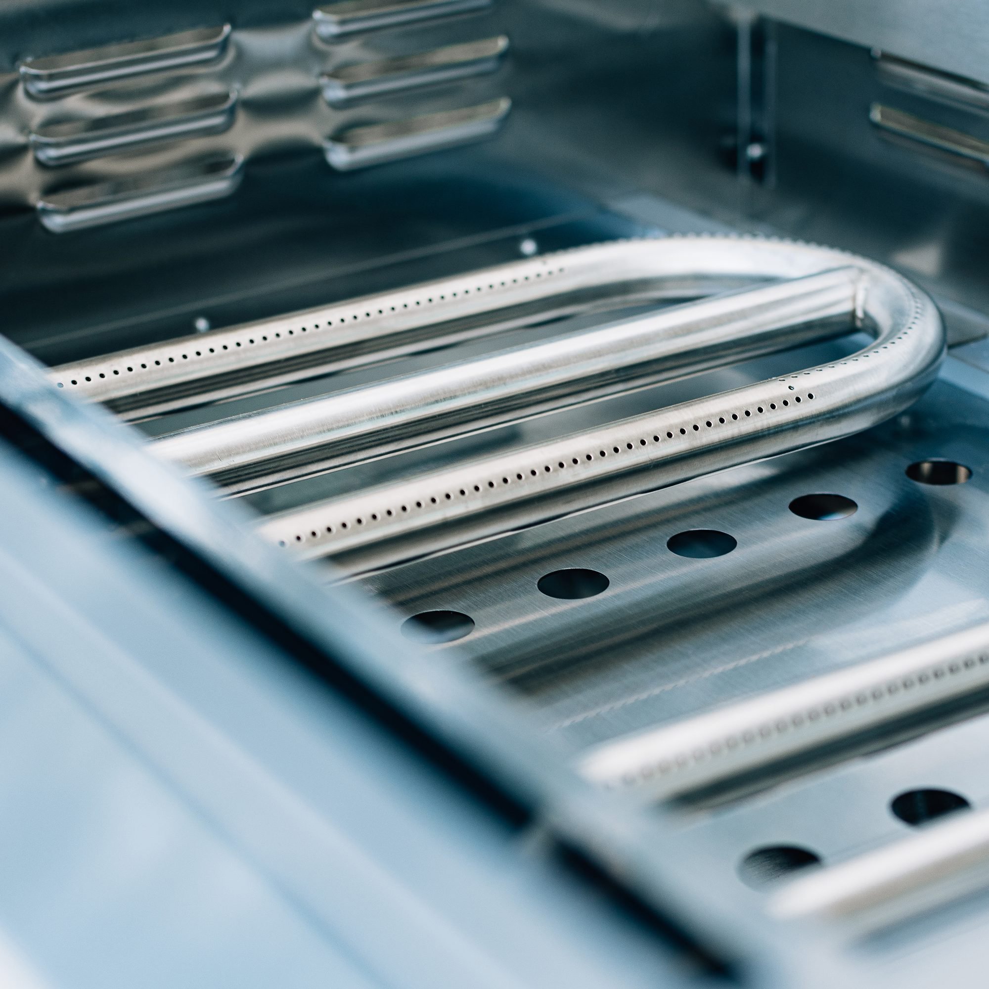 Interior view of the Summerset 30-inch Griddle Pro built-in gas griddle, showing the stainless steel U-tube burner and firebox drainage ports
