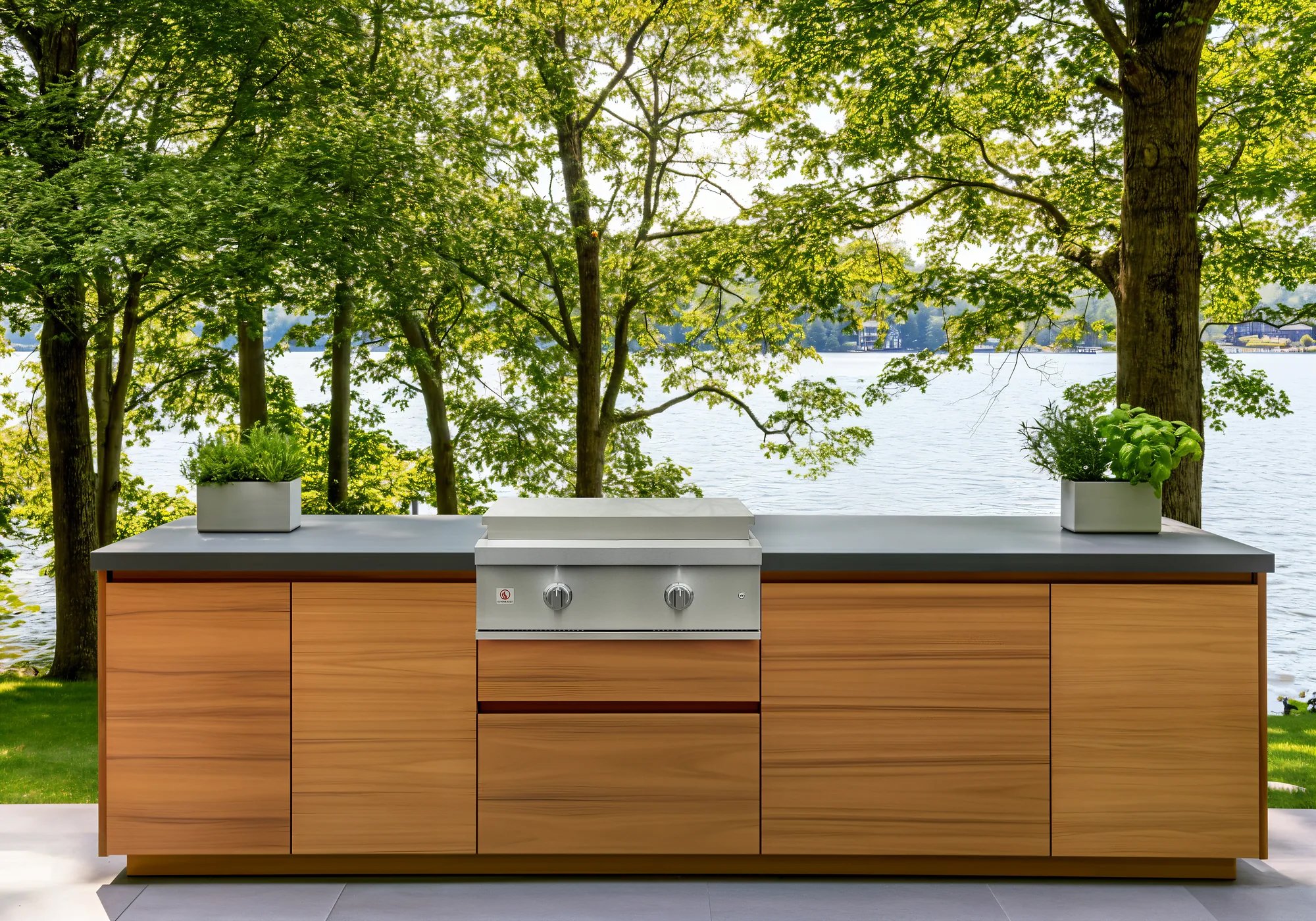 Summerset 30-inch Griddle Pro built-in gas griddle installed in a teak outdoor kitchen island overlooking a lake