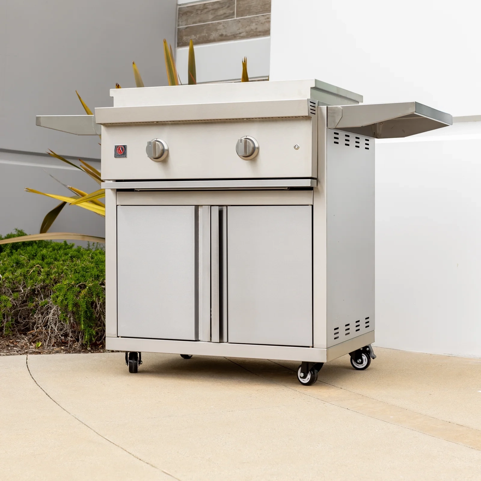 Summerset 30-inch Griddle Pro grill cart on an outdoor patio, angled view showing the stainless steel cart, folding side shelf, and double access doors